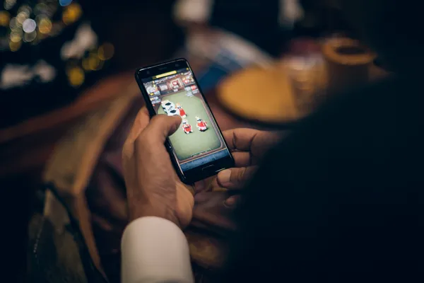 Jogos 25F — Descubra slots modernos e aventuras de mesa Um homem comemorando uma vitória em seu laptop enquanto símbolos de jogos flutuam ao redor, capturando a emoção dos jogos 25F.